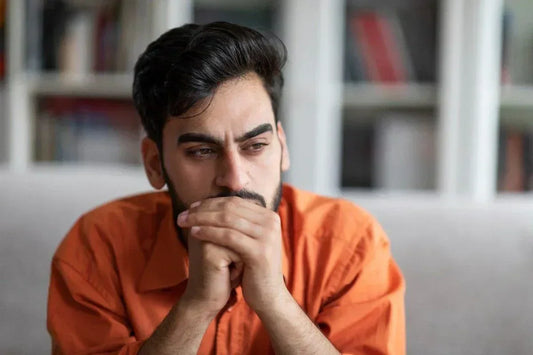 A man looking pensive and stressed, symbolizing anxiety, which can be alleviated through the science-backed benefits of magnesium glycinate.