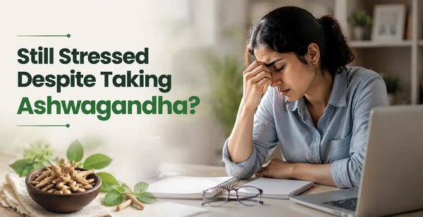 Woman experiencing stress at her desk despite taking ashwagandha, with a bowl of ashwagandha root nearby.
