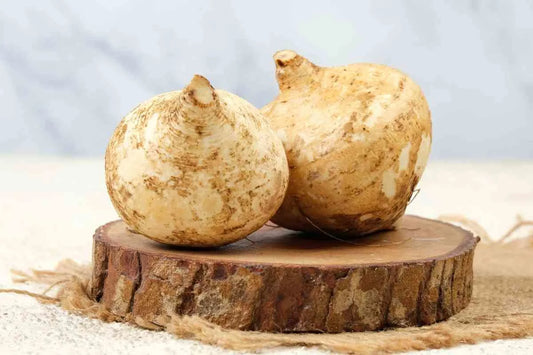 Two whole maca root tubers displayed on a rustic wooden stand, set against a soft background. Maca root is known for its benefits for men and women, including potential dosage and side effects.