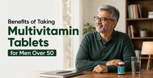 Confident older man holding multivitamin bottle at desk - why men over 50 should take daily multivitamin tablets.