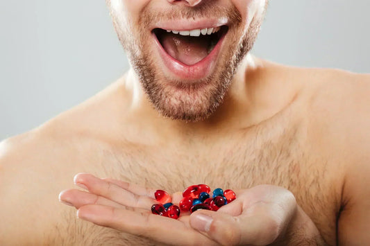 Man holding multivitamin capsules in hand for men's daily health and energy support.