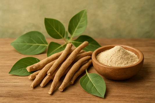 Dried Ashwagandha roots arranged beside a small wooden bowl filled with Ashwagandha powder on a wooden surface, accompanied by green leaves.
