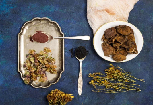 valerian root extract powder in a spoon, dried valerian roots in a bowl, and scattered valerian flowers on a blue background.